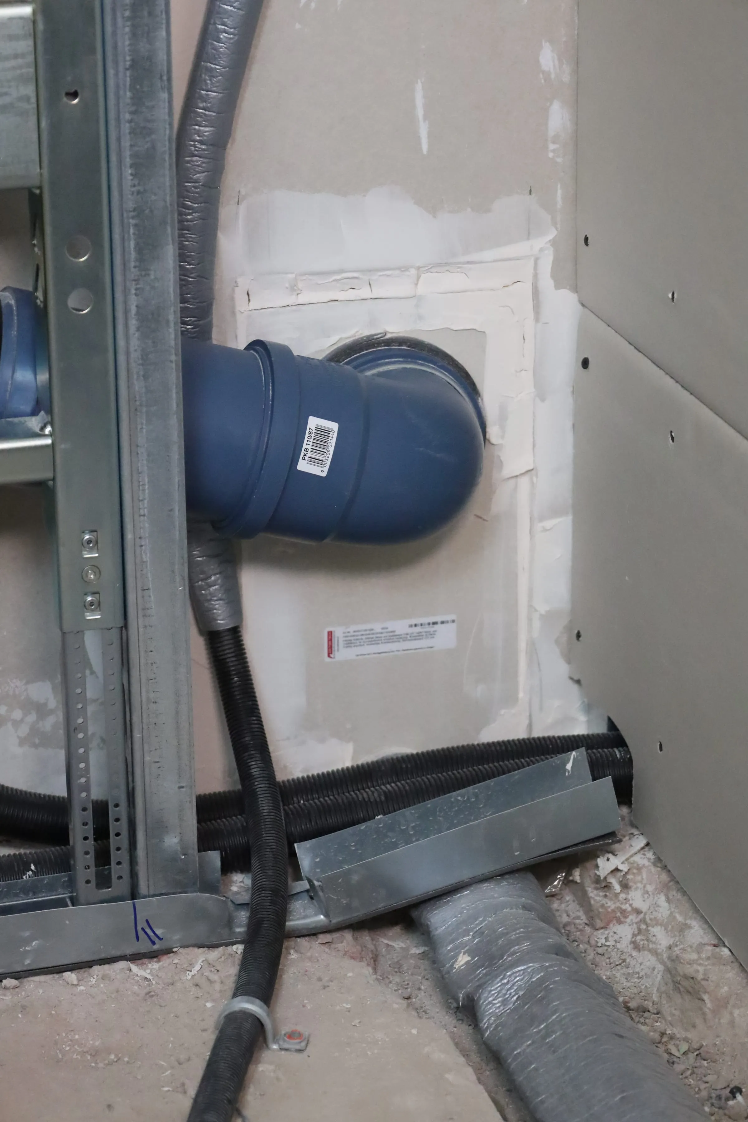 Een prefab afdichting met label om een afvoerbocht in een wandframe