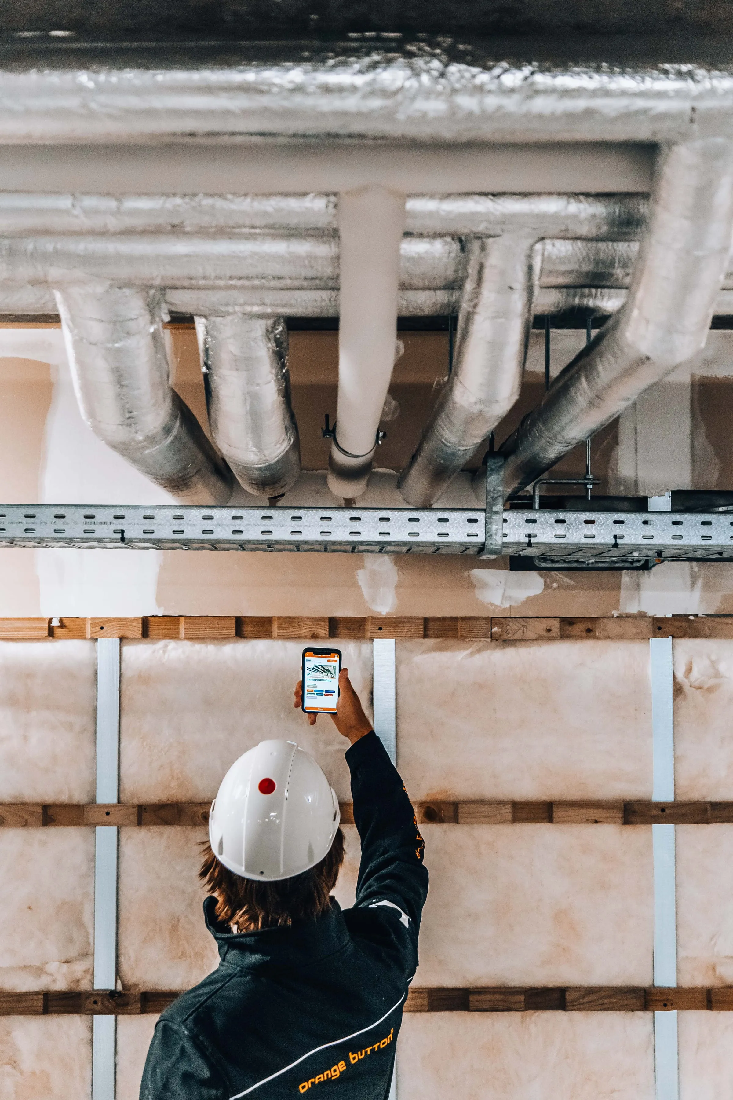 Een monteur fotografeert een doorvoering met de Orange Button-app